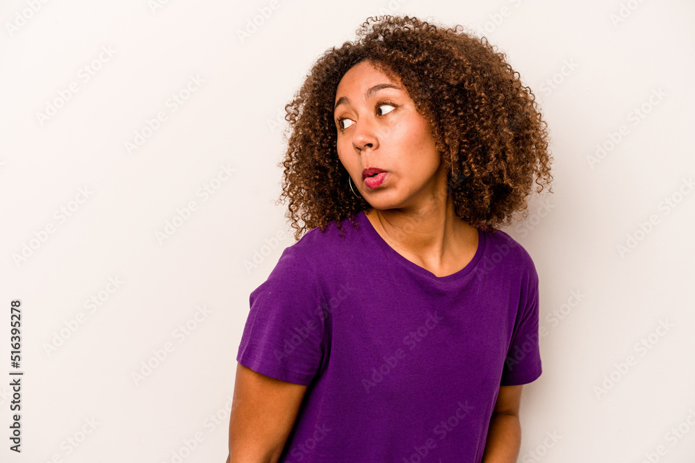Young African American woman isolated on white background looks aside smiling, cheerful and pleasant. Young African American woman isolated on white background looks aside smiling, cheerful and pleasant.