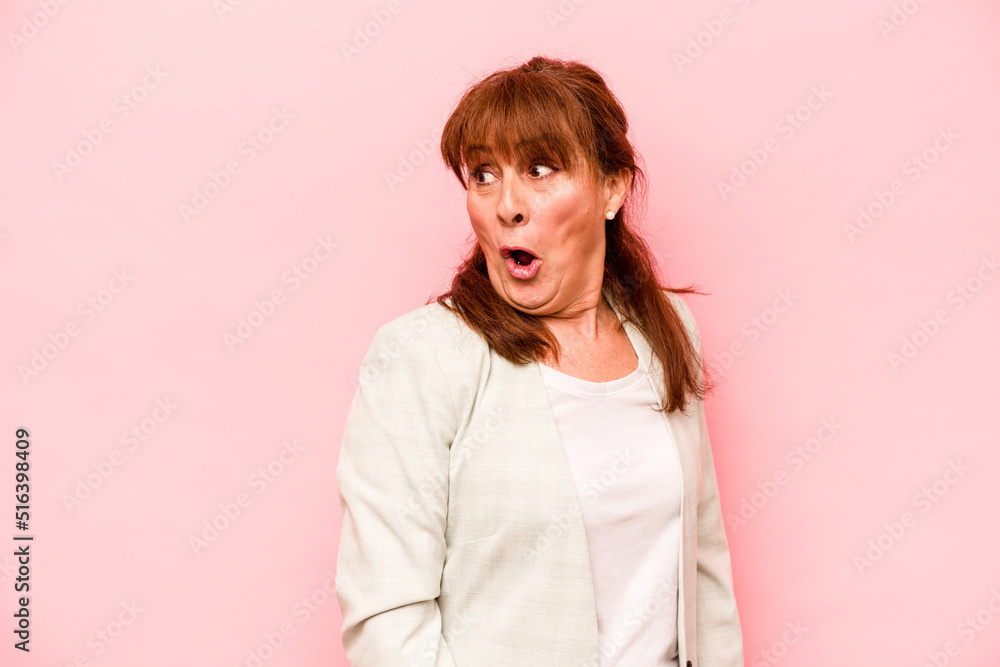 Middle age caucasian woman isolated on pink background looks aside smiling, cheerful and pleasant. Middle age caucasian woman isolated on pink background looks aside smiling, cheerful and pleasant.