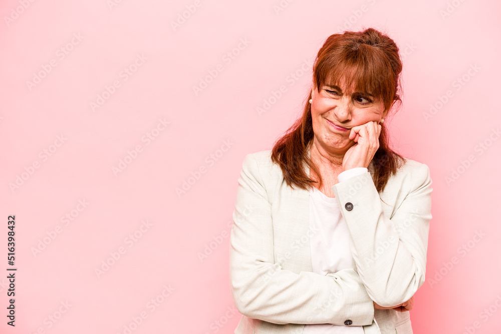 Middle age caucasian woman isolated on pink background who feels sad and pensive, looking at copy space. Middle age caucasian woman isolated on pink background who feels sad and pensive, looking at copy space.