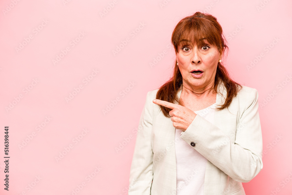 Middle age caucasian woman isolated on pink background pointing to the side Middle age caucasian woman isolated on pink background pointing to the side