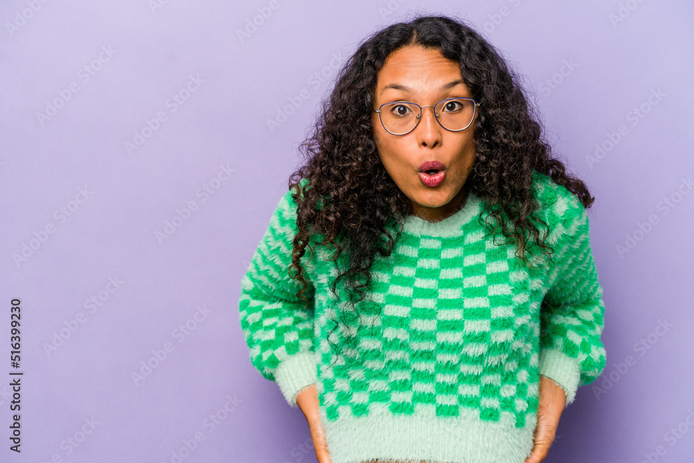 Young hispanic woman isolated on purple background being shocked because of something she has seen. Young hispanic woman isolated on purple background being shocked because of something she has seen.