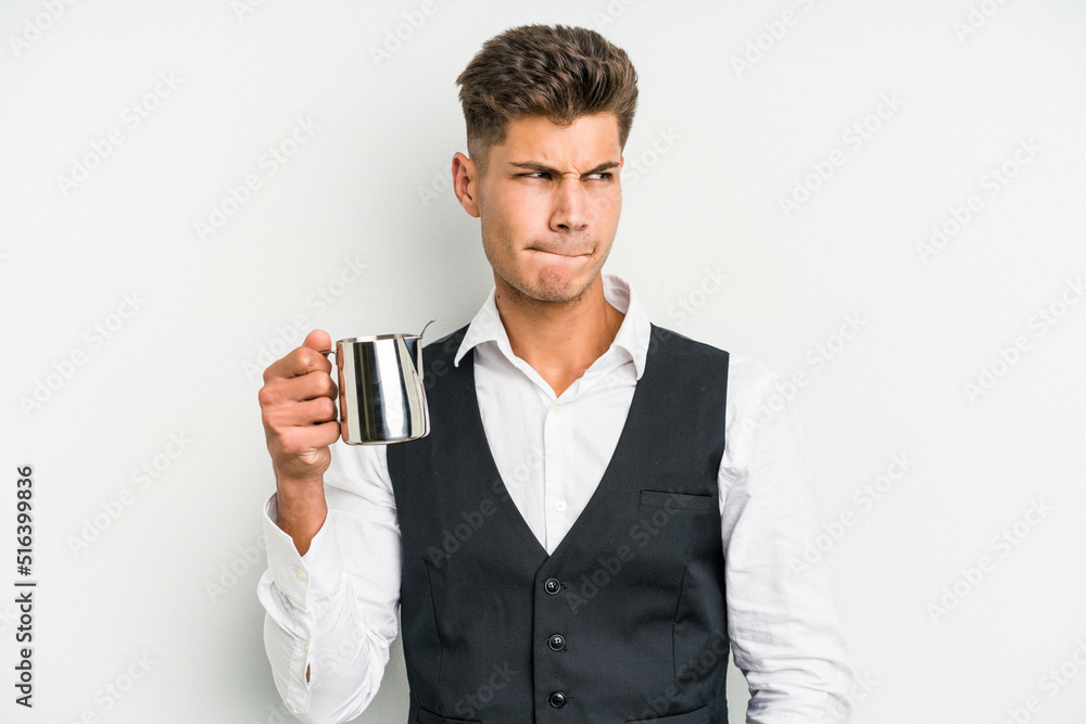 Young caucasian barista man isolated on yellow background confused, feels doubtful and unsure. Young caucasian barista man isolated on yellow background confused, feels doubtful and unsure.