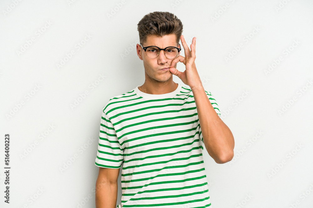 Young caucasian man isolated on white background with fingers on lips keeping a secret. Young caucasian man isolated on white background with fingers on lips keeping a secret.