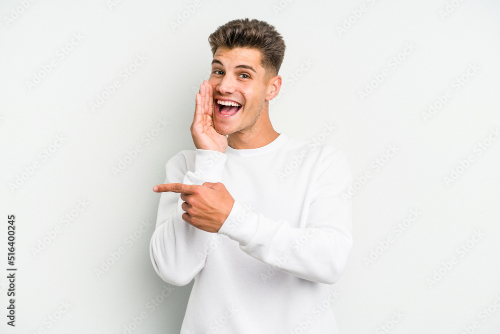 Young caucasian man isolated on white background saying a gossip, pointing to side reporting something. Young caucasian man isolated on white background saying a gossip, pointing to side reporting something.
