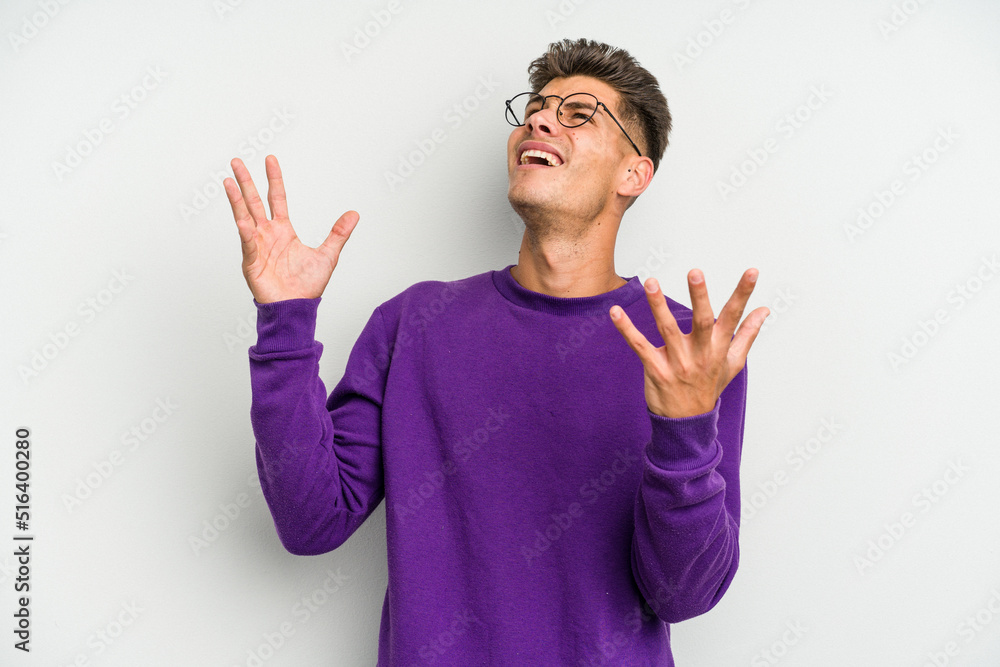 Naklejka premium Young caucasian man isolated on white background screaming to the sky, looking up, frustrated.