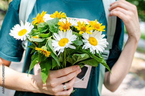 A bouquet of wild flowers in the hands of a married woman.