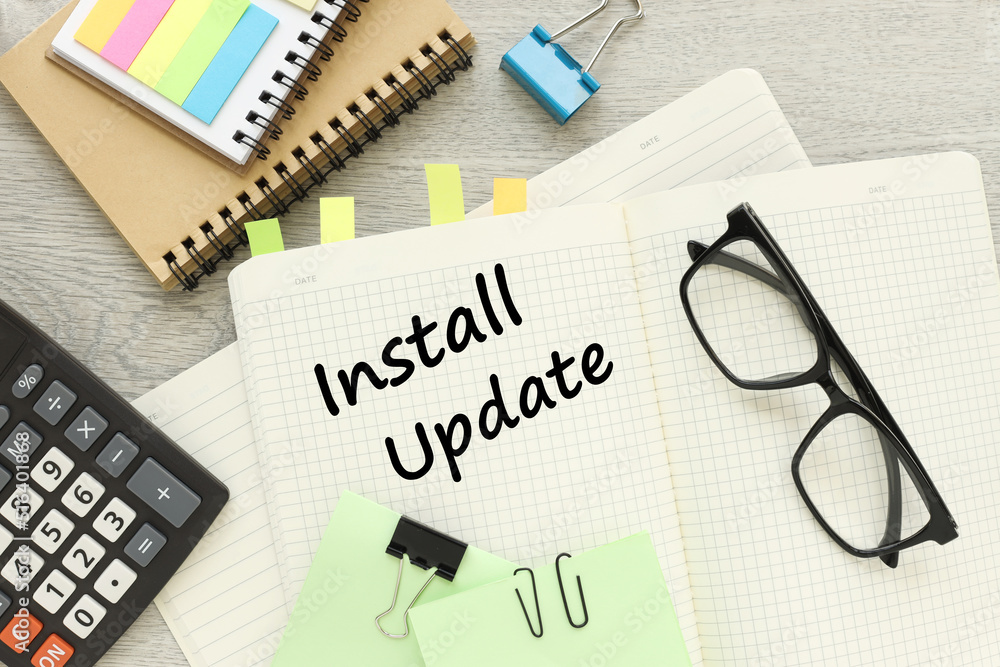 Install updates button . text on a notepad near glasses and stickers. Install updates button . text on a notepad near glasses and stickers.