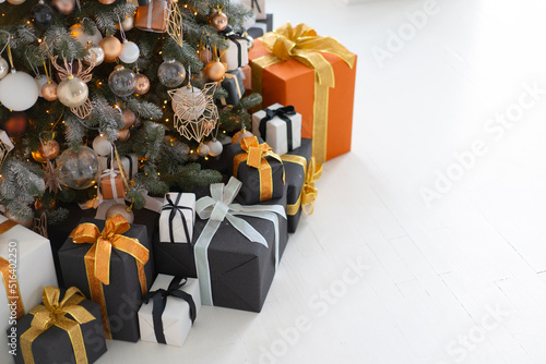 Christmas present box black, orange and white color on white floor with copy space