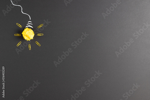 Image of a bulb made of paper ball and rockers over dark background
