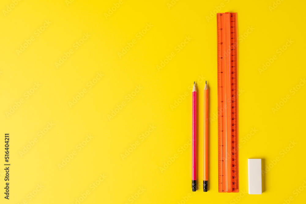 Composition of rulers, pencils and eraser on yellow surface with copy space Composition of rulers, pencils and eraser on yellow surface with copy space
