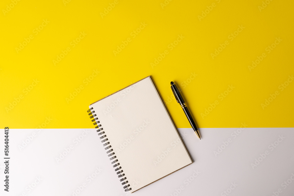 Image of notebook with copy space and pencil on yellow and white surface Image of notebook with copy space and pencil on yellow and white surface