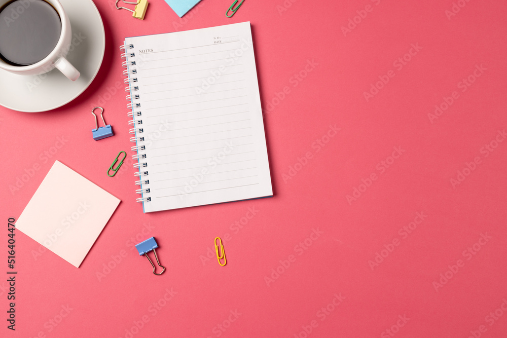 Image of notebook with copy space, pins and coffee on pink background Image of notebook with copy space, pins and coffee on pink background