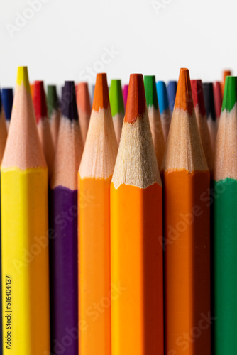 Vertical image of colorful crayons on white surface