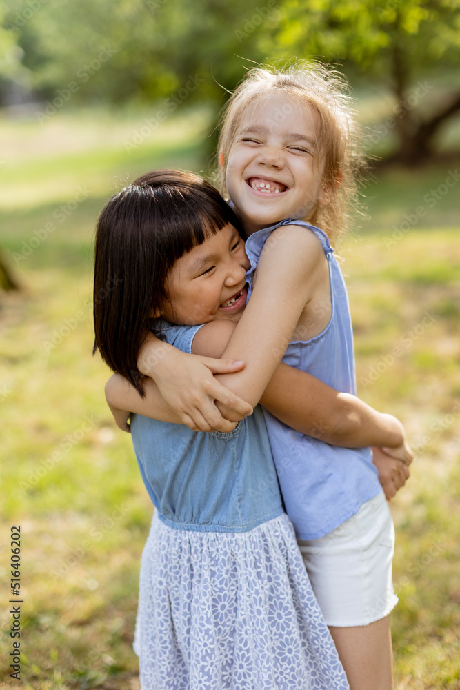 Cute asian and caucasian girl having fun in the park Cute asian and caucasian girl having fun in the park