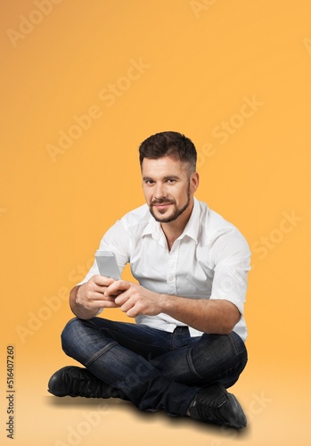 Young person using smartphone on color background © BillionPhotos.com