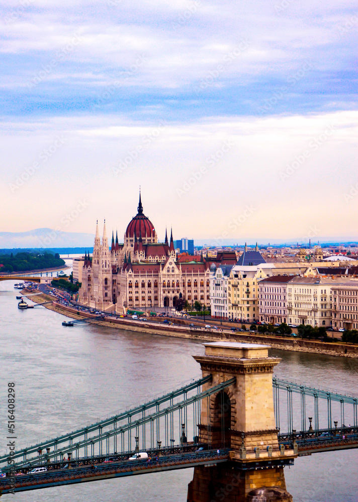 Obraz premium Budapest Parliament with its characteristic red dome towering over the Danube river. 