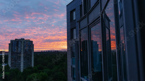 sunset over the city. Sunset in the windows of the new building. Building new areas on the outskirts of a big city.
