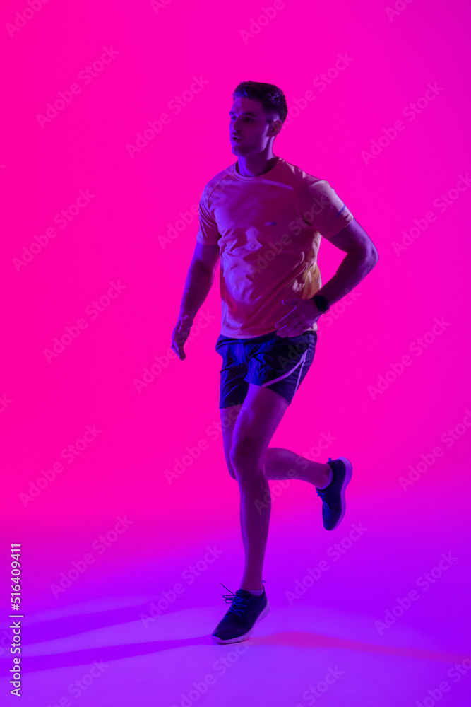 Caucasian male tennis player running over neon pink lighting Caucasian male tennis player running over neon pink lighting