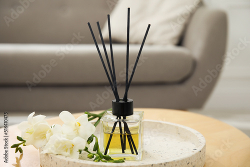 Reed diffuser with freesia on table in living room