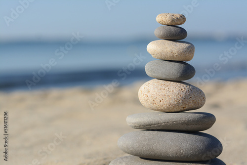 Stack of stones on sandy beach  closeup. Space for text