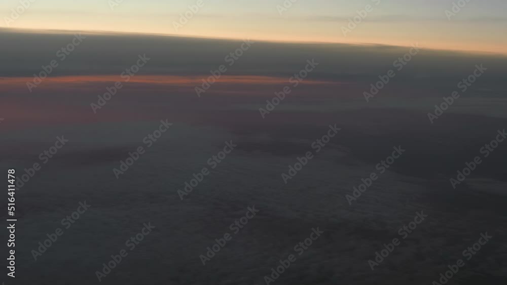 Aerial view from airplane porthole on picturesque cloudscape at sunset time. Looking out of window of flying at sunset time airplane Aerial view from airplane porthole on picturesque cloudscape at sunset time. Looking out of window of flying at sunset time airplane