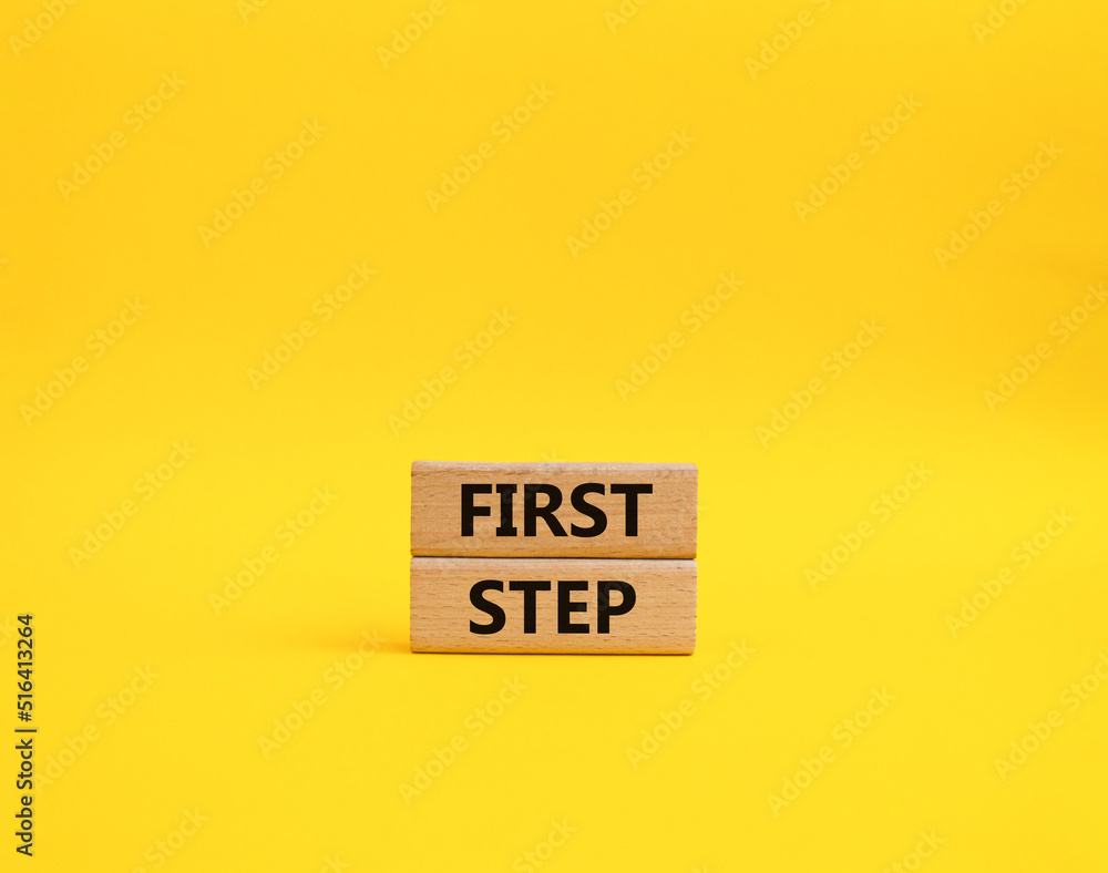 Naklejka premium First step symbol. Wooden blocks with words 'First step'. Beautiful yellow background. Business and 'First step' concept. Copy space.