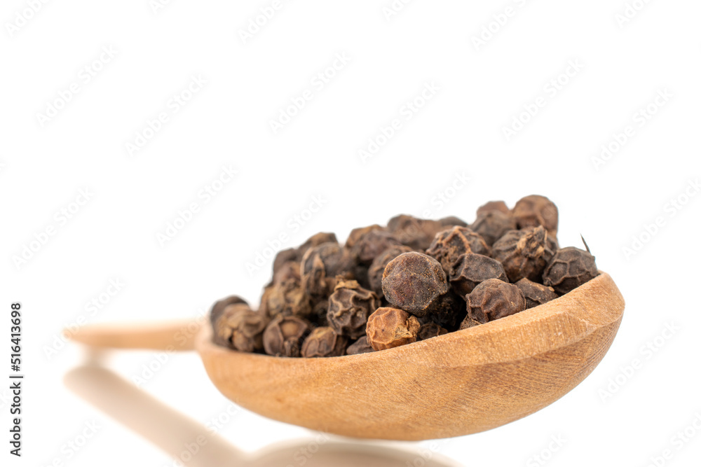 Dry fragrant black pepper in a wooden spoon, close-up, isolated on a white background. Dry fragrant black pepper in a wooden spoon, close-up, isolated on a white background.