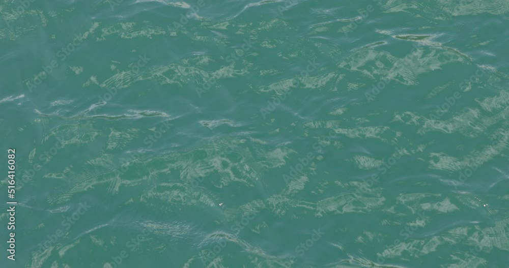 Surface of the lake, the clear blue and green colored water flows forming small waves. Surface of the lake, the clear blue and green colored water flows forming small waves.