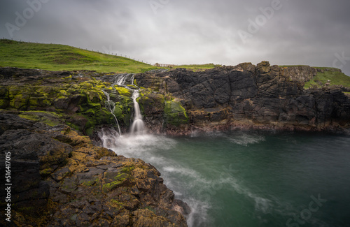 long exposure view of the picturesque Irish coast and Dunseverick waterfall in summer