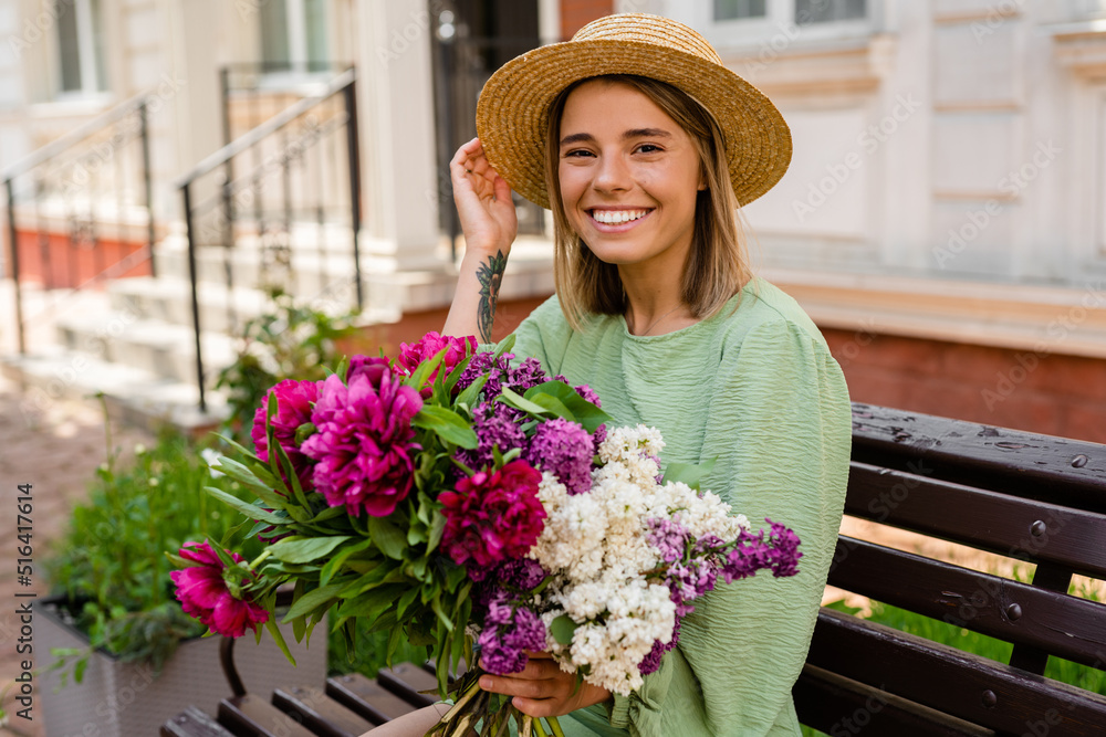 beautiful young woman in summer style outfit smiling happy walking with flowers in city street