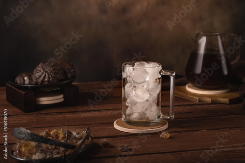Fototapeta Naklejka Na Ścianę i Meble -  Glass with ice. Nearby is a coffee pot, a jug of cream, marshmallows, and caramelized sugar. Cold refreshing coffee summer drink.