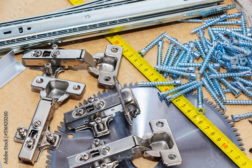 Screws, confirmations for furniture, tape measure, lie on the table. Furniture production photo