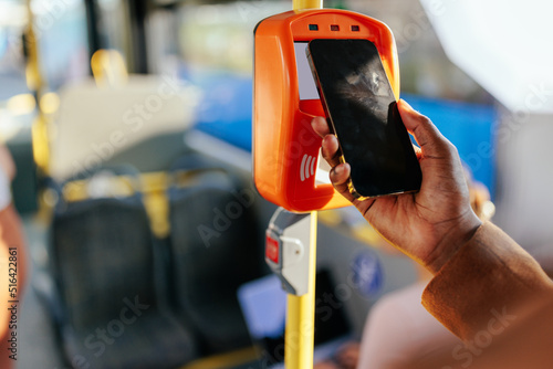 Man scanning cellphone to pay commute fare photo