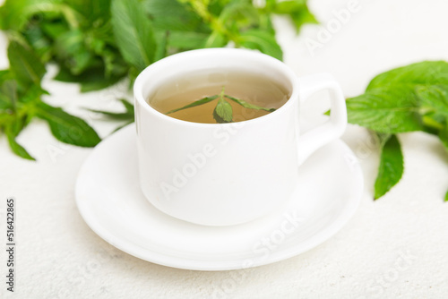 Cup of mint tea on table background. Green tea with fresh mint top view with copy space