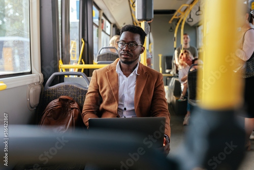 African american businessman is working while commuting and looking through window