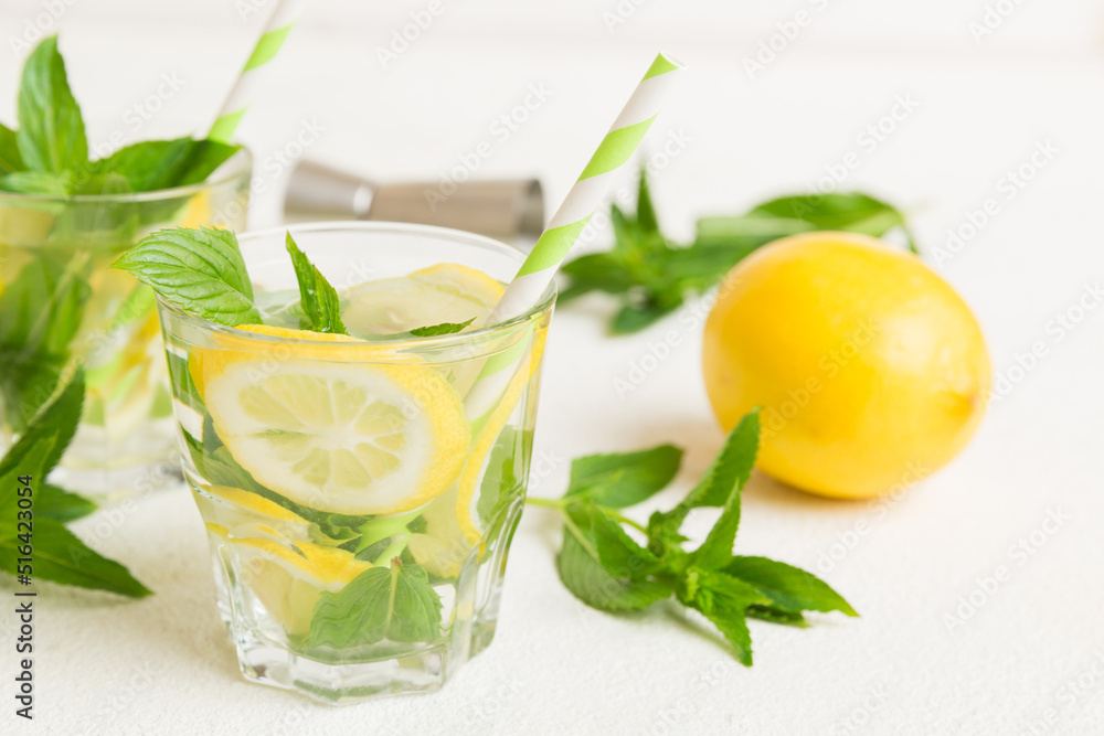 Mojito cocktail. Refreshing mojito cocktail with lime, lemon and mint in a tall glass with a stick Mojito cocktail. Refreshing mojito cocktail with lime, lemon and mint in a tall glass with a stick