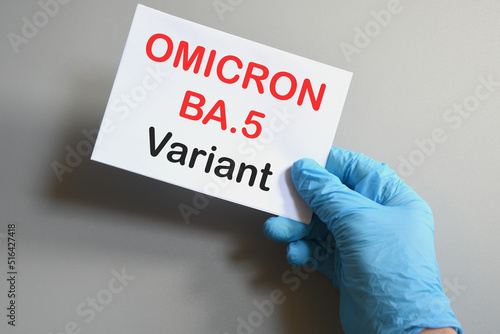 Covid-19 new Omicron variants. Hand of the doctor in blue glove hold a white paper with text "Omicron BA.5 Variant". Concept for the new Covid 19 Omicron variants