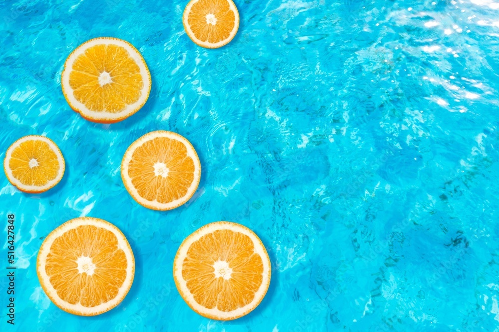 Creative summer composition made of sliced orange in transparent pool water. Refreshment concept. Healthy drink theme. Creative summer composition made of sliced orange in transparent pool water. Refreshment concept. Healthy drink theme.