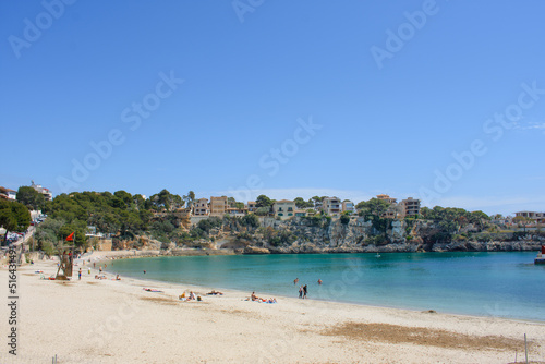 Porto Cristo, Mallorca, Spain - 05.02.2022: Half empy beach of Porto Cristo with houses on top of the coastal cliffs in background