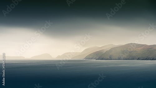 Foto Breathtaking view of the Dingle Peninsula from the Atlantic Ocean on dark cloudy