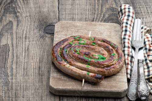 Fototapeta Naklejka Na Ścianę i Meble -  Grilled rolled thin lamb sausages on wooden table