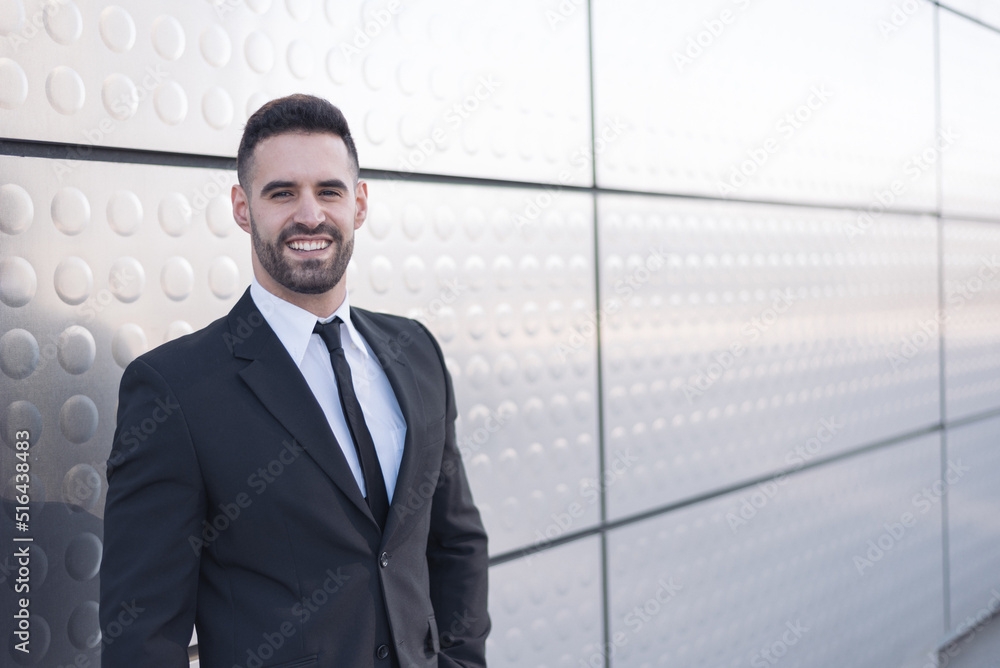 businessman in suit at silver building wall