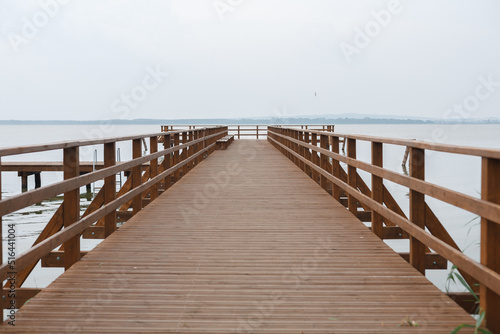 An empty  wide  wooden pier over the lake