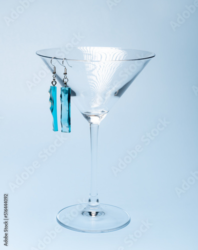 epoxy resin jewelry earrings. stylish fashionable photo of earrings on glass background. symmetrical handmade earrings in turquoise color bare. women holiday gift giving jewelry concept