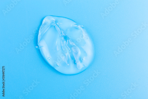 Moisturizing transparent face cream gel smeared isolated on blue background.