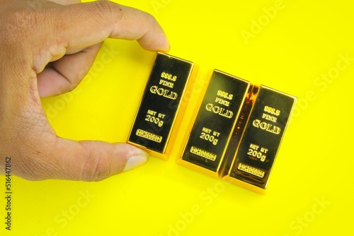 hand holding three 200g gold ingots. the concept of gold or worth photo