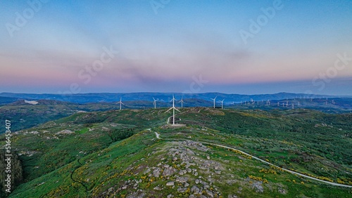 Aerial shot of wind turbines with a green landscape