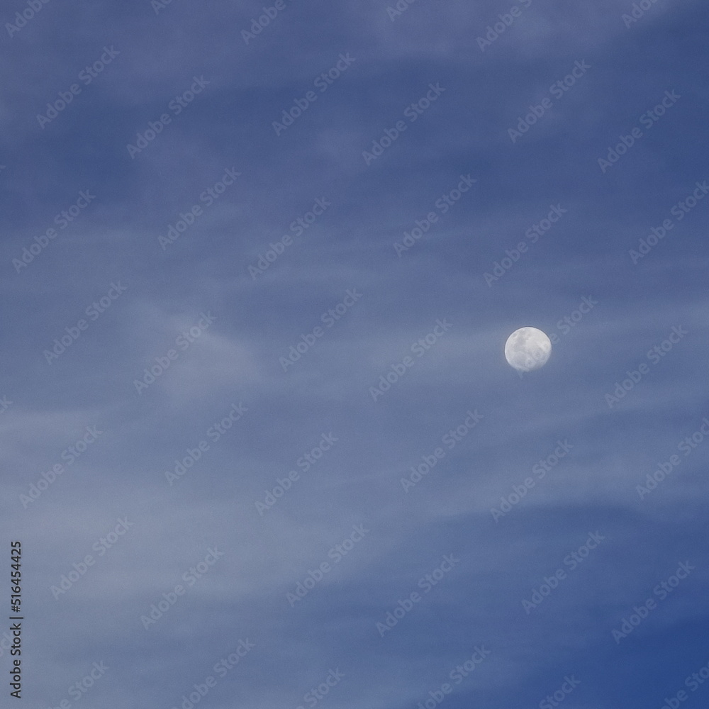 A moon rising against the clouds