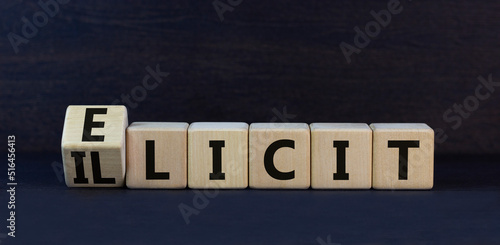 Illicit or elicit symbol. Turned wooden cubes and changed the concept word Illicit to Elicit. Beautiful black table black background. Business illicit or elicit concept. Copy space.