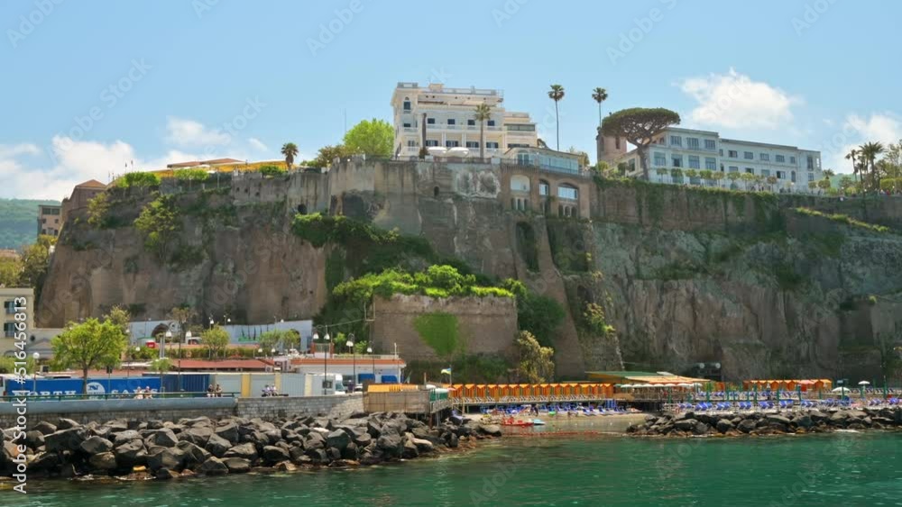 View of the Tyrrhenian sea coast in Sorrento, Italy. Classic buildings, beach, cliff. View from a ship View of the Tyrrhenian sea coast in Sorrento, Italy. Classic buildings, beach, cliff. View from a ship